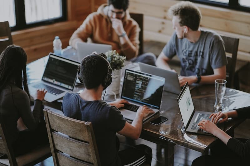 Corporate team reviewing AI software on laptops in a meeting room